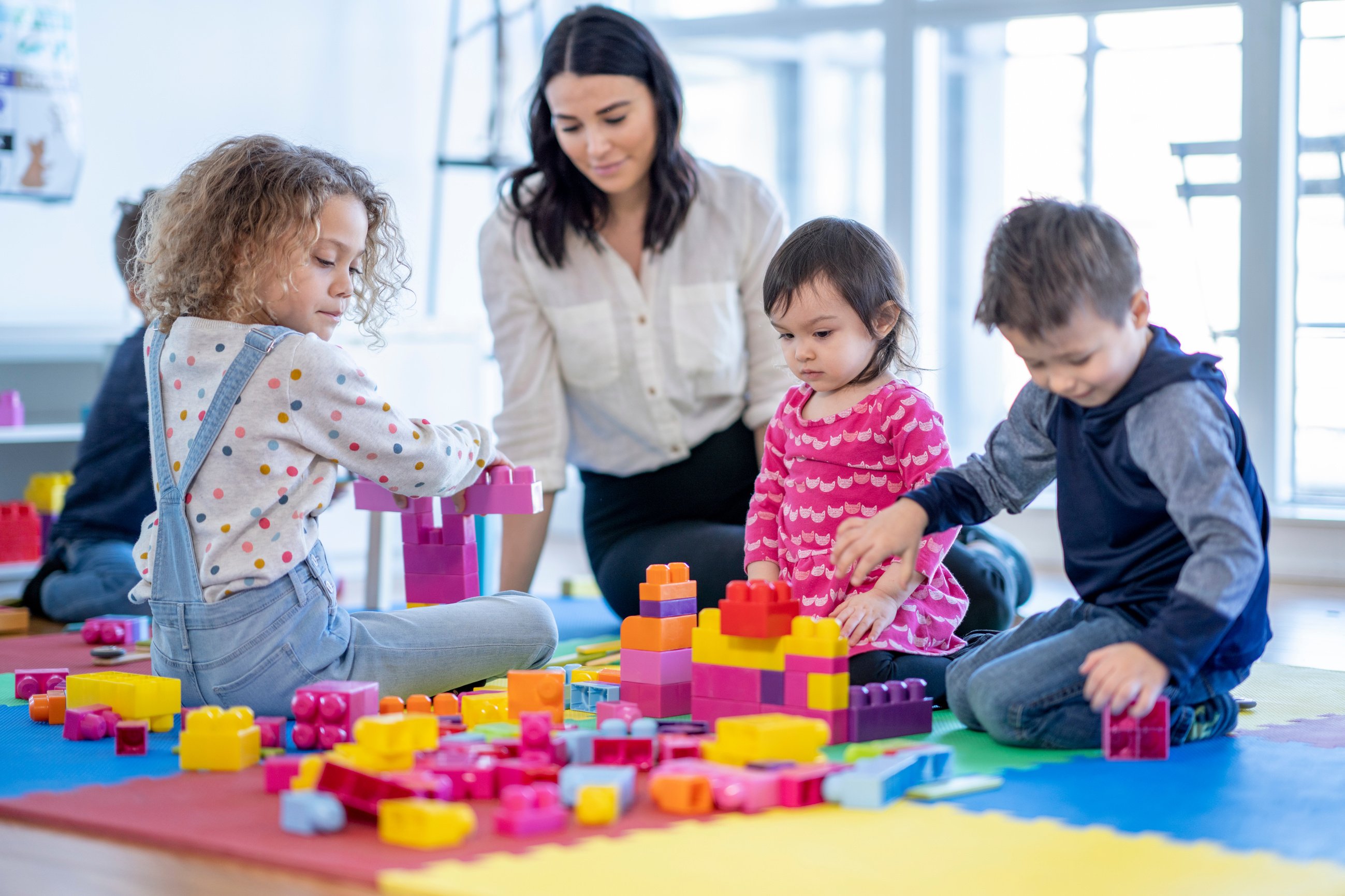 Childcare Provider Playing with Children stock photo